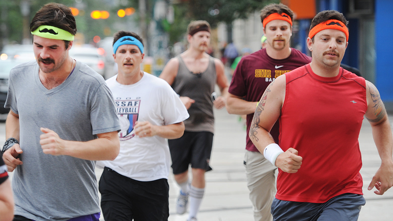 Men with mustaches run in a Movember race.